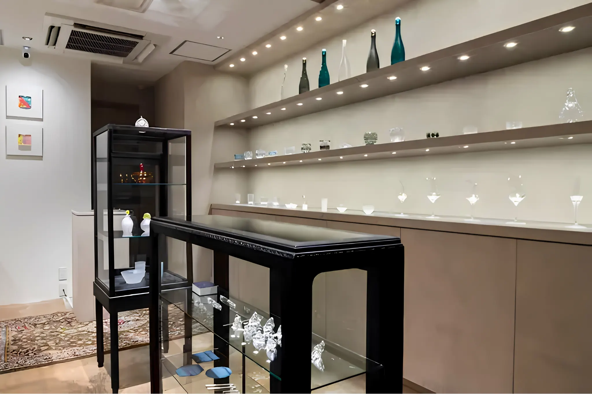 A quiet Kiriko cut-glass gallery with glassware on white shelves