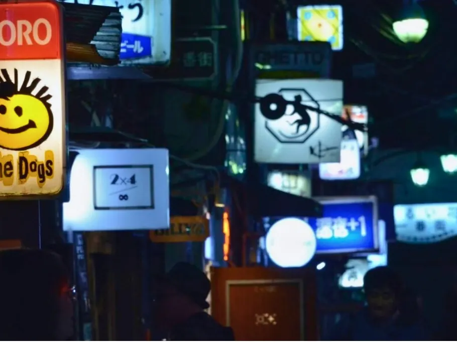 Colorful bar signboards crowding a narrow Golden Gai alley