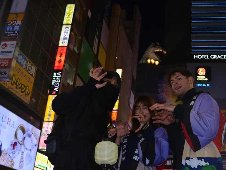 Guests posing with their Ninja guide under Kabukicho neon