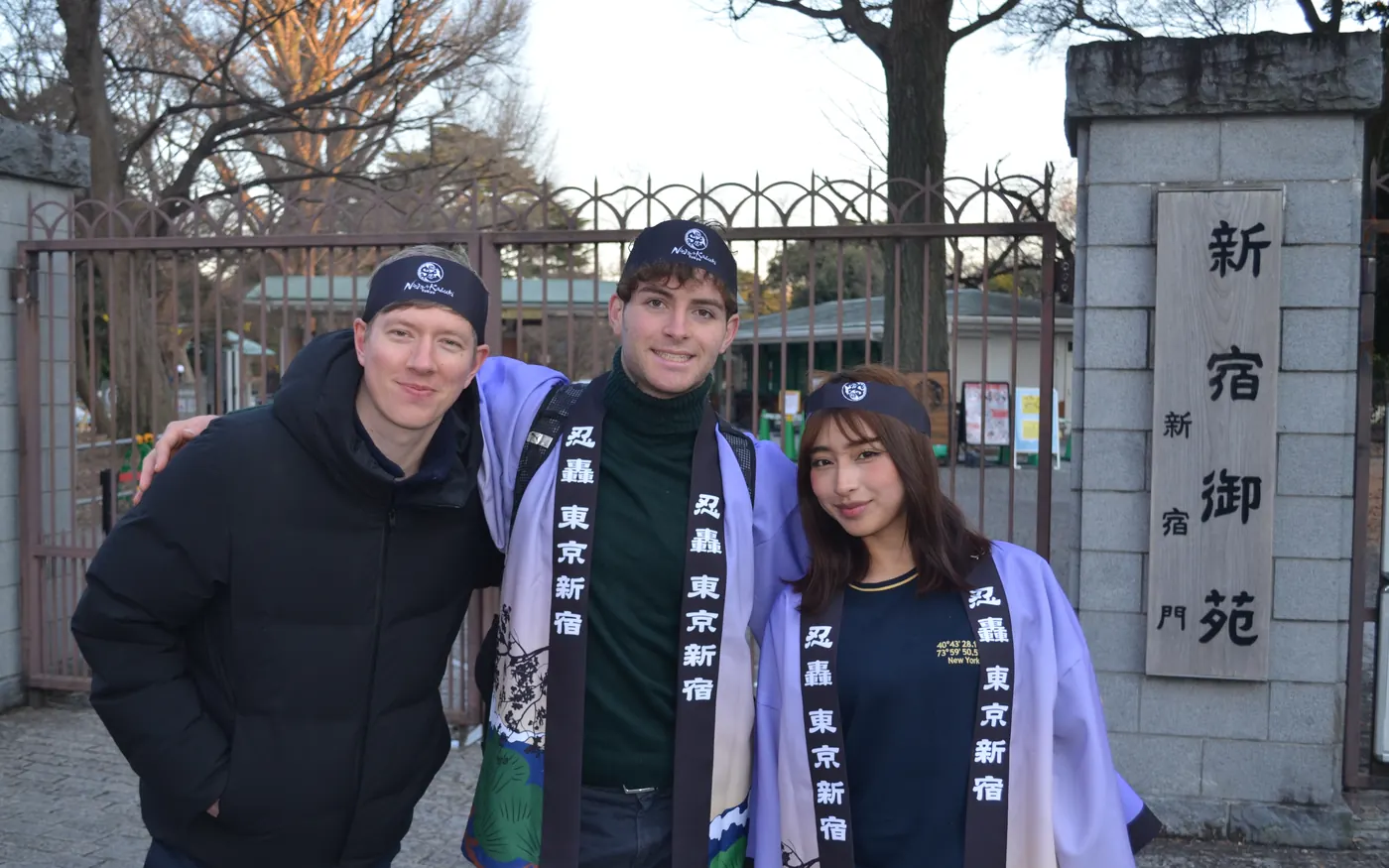 Three smiling guests with their Ninja guide at the Shinjuku Gyoen gate