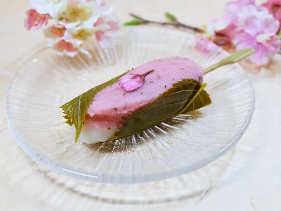 Sakura mochi on a glass plate with cherry blossoms