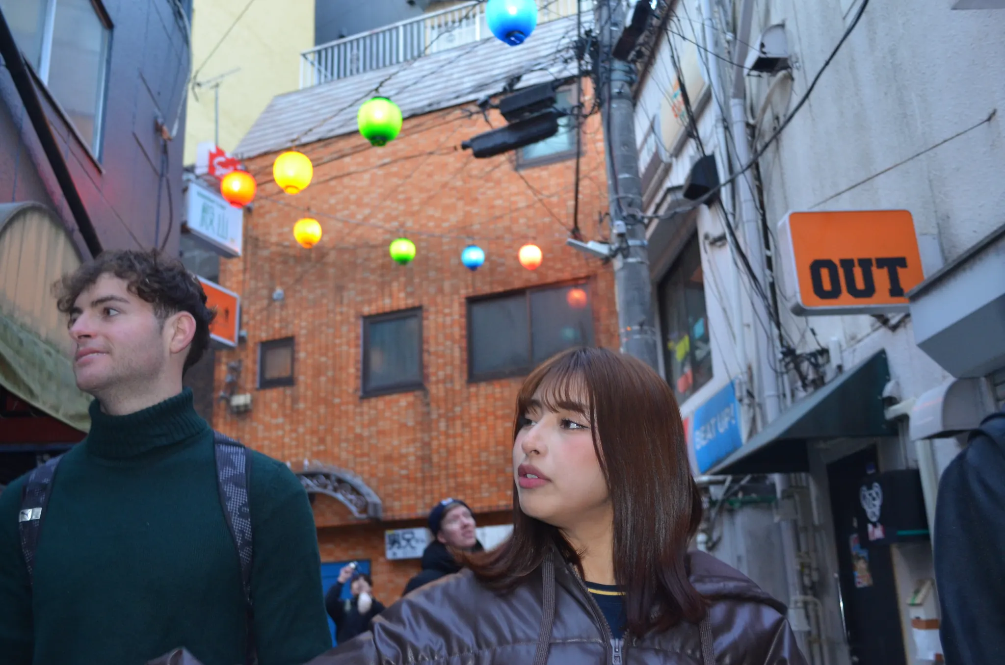 Guests looking around a Nichome street hung with colorful lanterns
