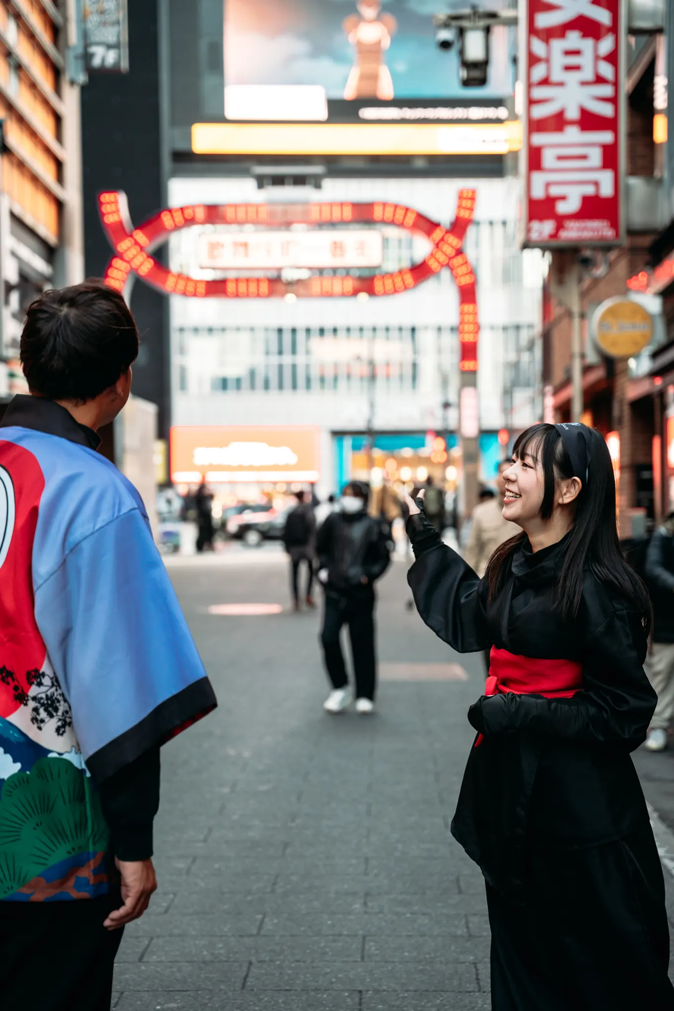 A guest laughing with the guide in front of the Kabukicho gate