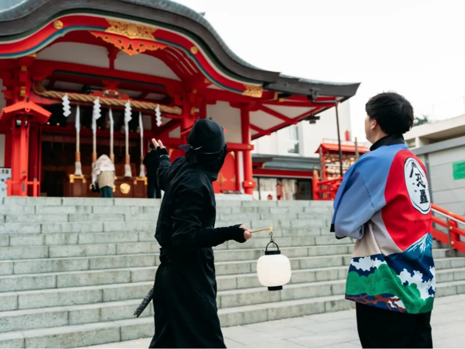 A guest and the Ninja guide at the steps of Hanazono Shrine